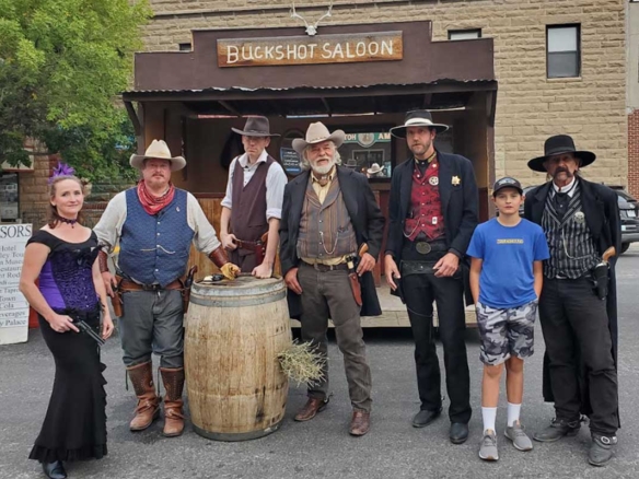 Visitors exploring downtown Cody Wyoming with Western storefronts, local businesses, and mountain scenery.
