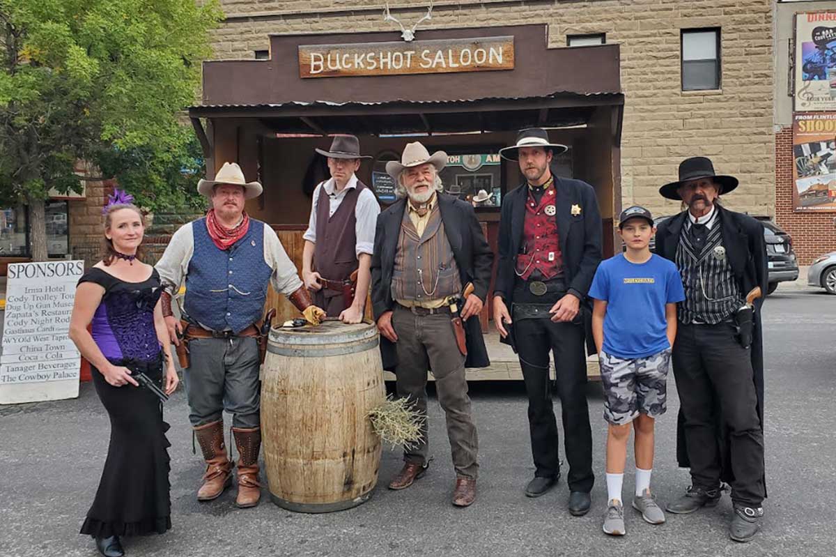 Visitors exploring downtown Cody Wyoming with Western storefronts, local businesses, and mountain scenery.